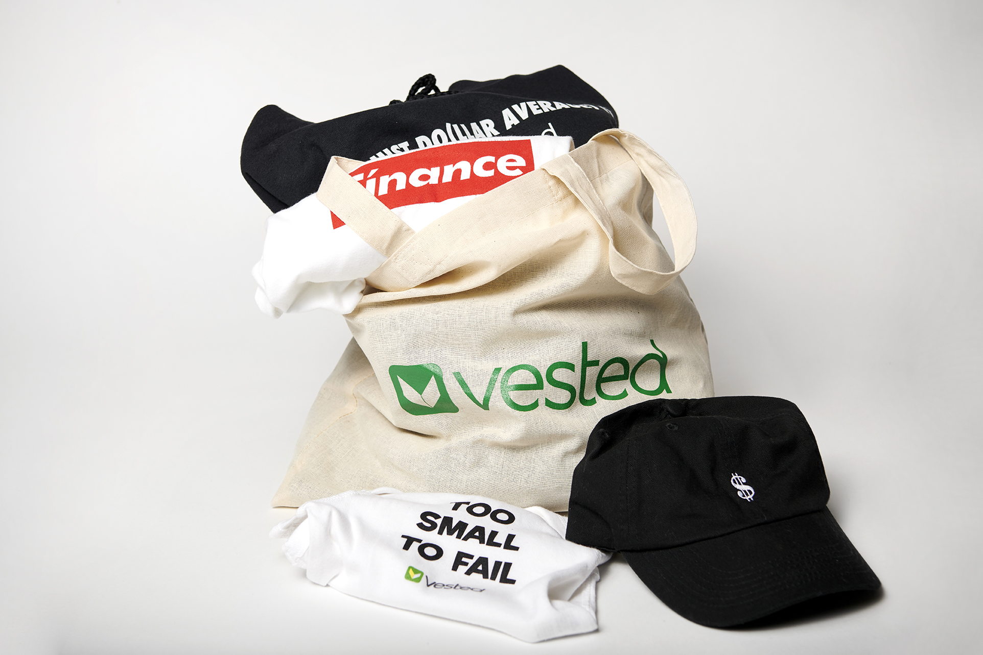 Various printed hats, tote bags, and t-shirts with Vested related logos and slogans.