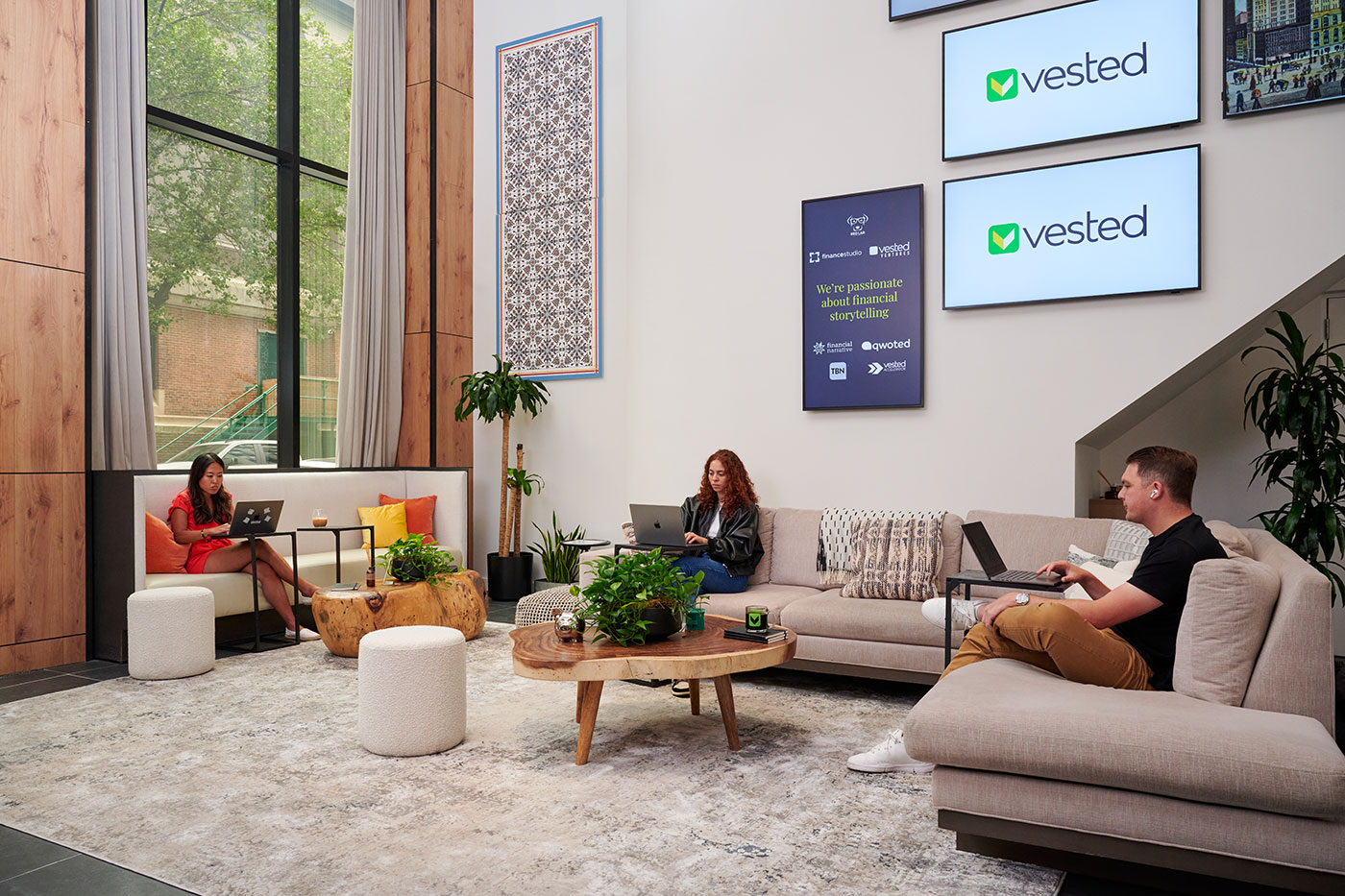 A casual seating area with comfy couches and Vested team members working.