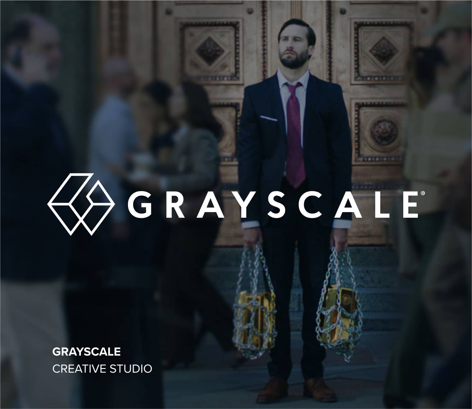 A visual logo for Grayscale Creative Studio showing a man in a business suit holding chain bags of books in front of an ornate door.