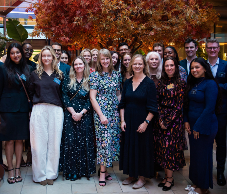 Large group of Vested team members gathered together at an indoor networking or company event