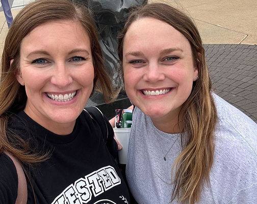 Two Vested team members smiling together outdoors at a company event